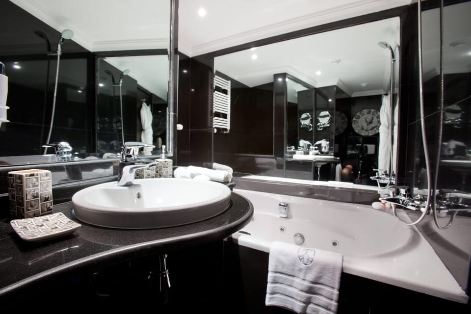 Prestige Suite with Balcony | Bathroom | Deep soaking tub, rainfall showerhead, designer toiletries, hair dryer