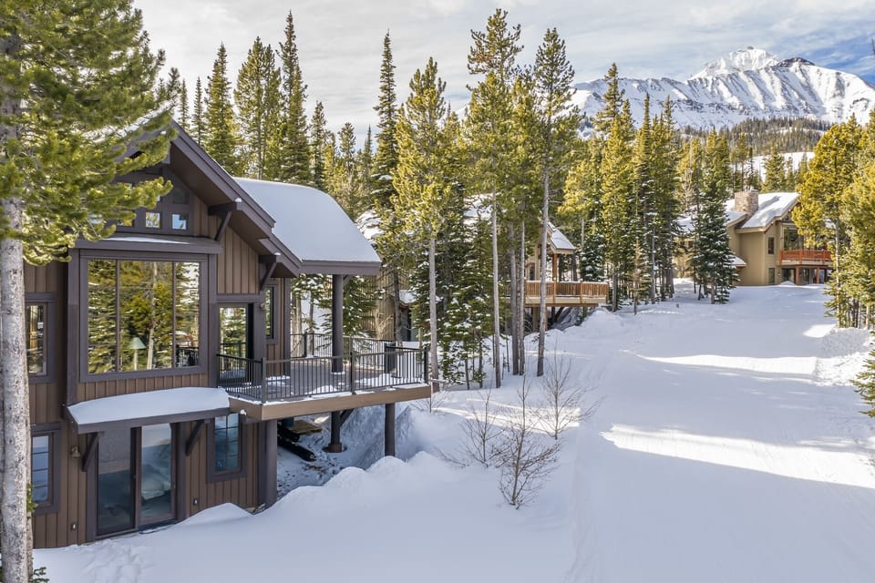 Mountain retreat nestled among snow-covered pines with stunning alpine views and nearby ski access.