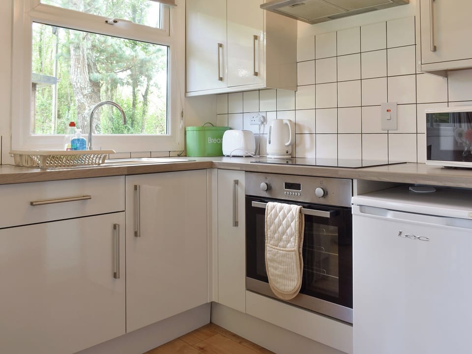 Fully equipped kitchen with dining area within the open-plan design | Chalet 2 - Mount Hawke Holiday Bungalows, Mount Hawke, near Redruth