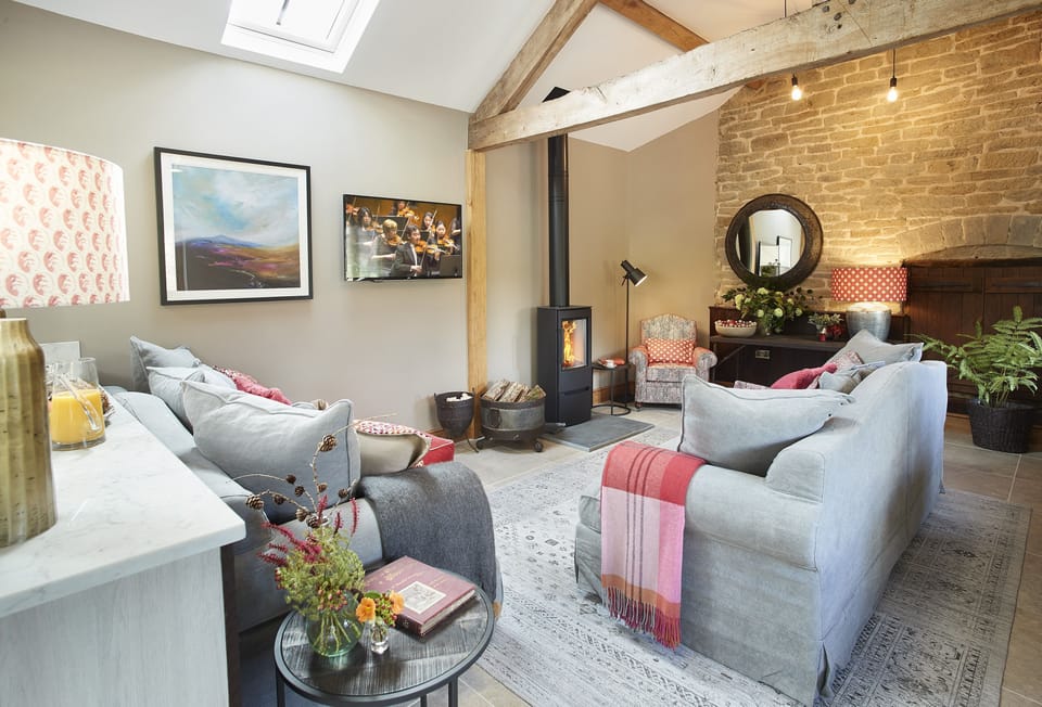 Exposed beams, stone wall and plush furnishings