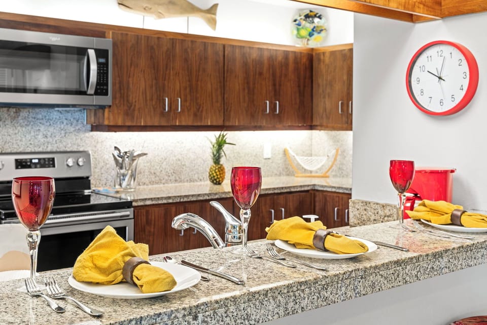 The fully equipped kitchen features granite counters, quality appliances, and elegant table settings for memorable meals.