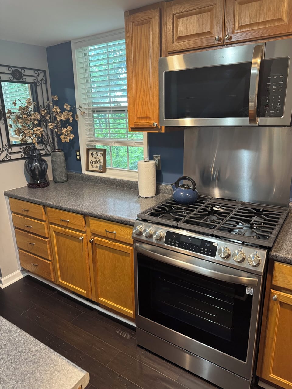 View of the kitchen area with stove and microwave. 