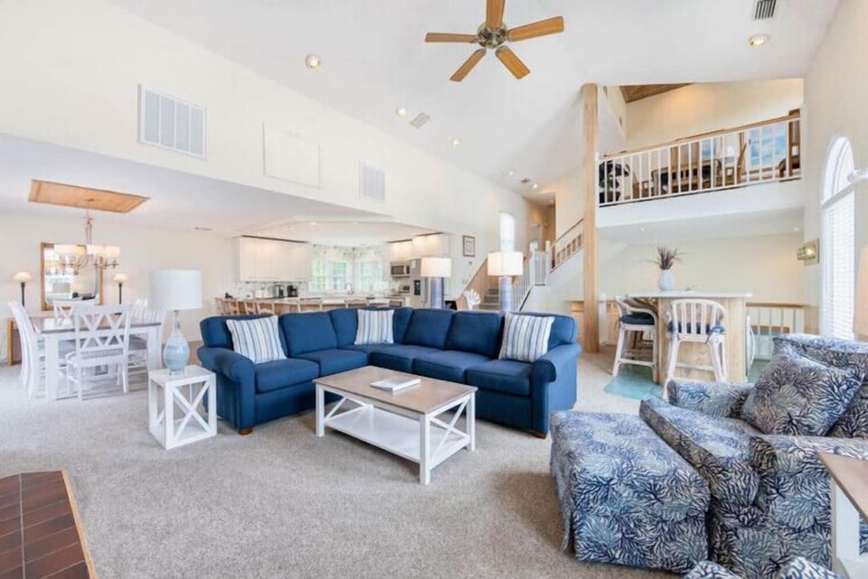 Settle into your spacious open-concept living area, where soaring vaulted ceilings and coastal blue furnishings invite you to relax after a day of adventure.