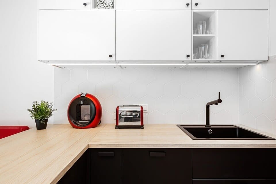 Fully equipped space with red and white color contrast, including all necessary appliances.