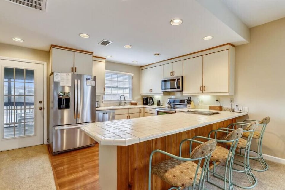 Your fully equipped kitchen invites effortless meal prep with stainless steel appliances, ample counter space, and a cheerful breakfast bar where you can gather over morning coffee.
