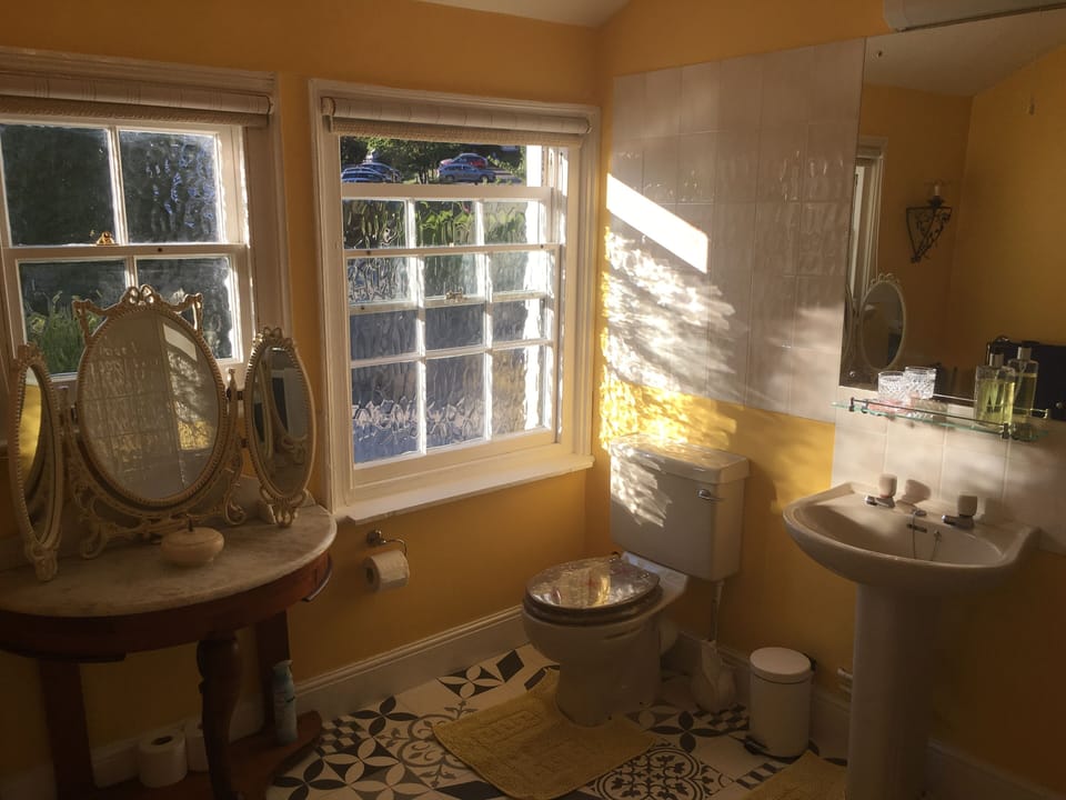 Large bathroom with electric shower, bath and heated towel rail. 