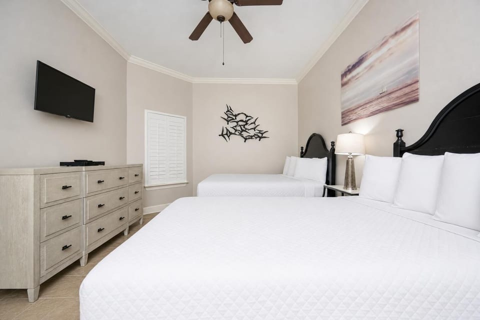 Drift into peaceful slumber on two queen beds, embracing a tranquil vibe while resting with loved ones in this guest room