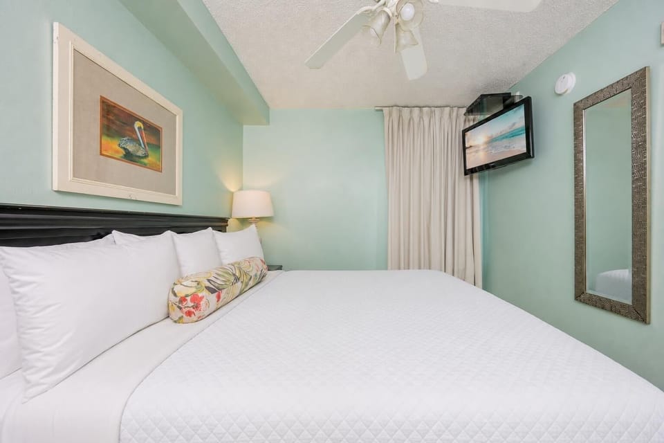 Fluffy pillows invite you to relax in the king suite for a calm movie night after a fun day at the beach