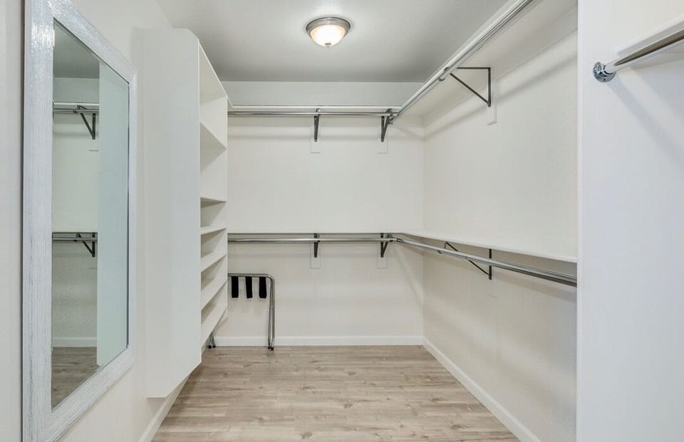 Oversized master closet with lots of hanging space and shelving.