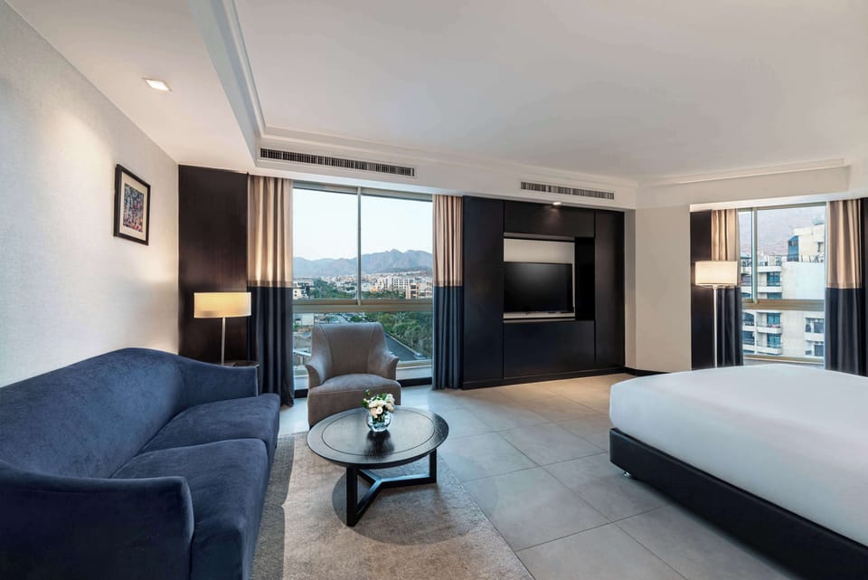 King Deluxe Corner Room with City View | Living area | 43-inch LCD TV with satellite channels, TV