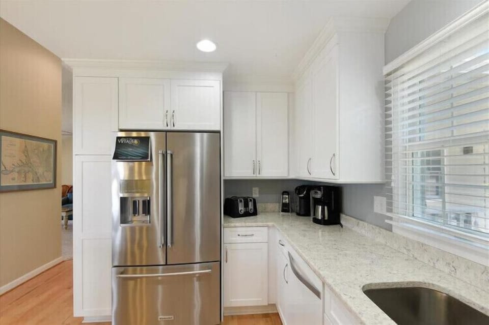 Your fully equipped kitchen features stainless steel appliances, granite countertops, and a coffee maker ready to brew your morning cup in this bright, modern space.