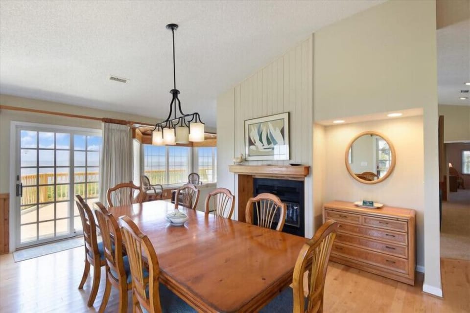 Gather around this warm dining space where sunlight streams in through expansive windows, perfect for memorable meals and easy access to your outdoor retreat.