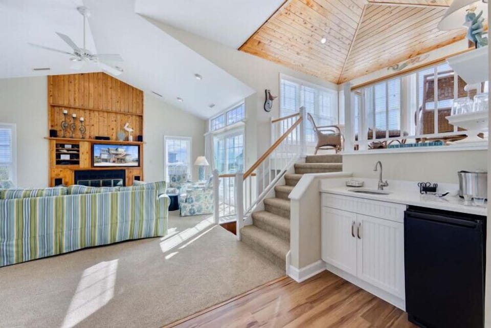 Relax in your bright, open living space with soaring ceilings and a cozy loft above. Sunlight pours in, warming the wood accents and inviting you to unwind after a day exploring.