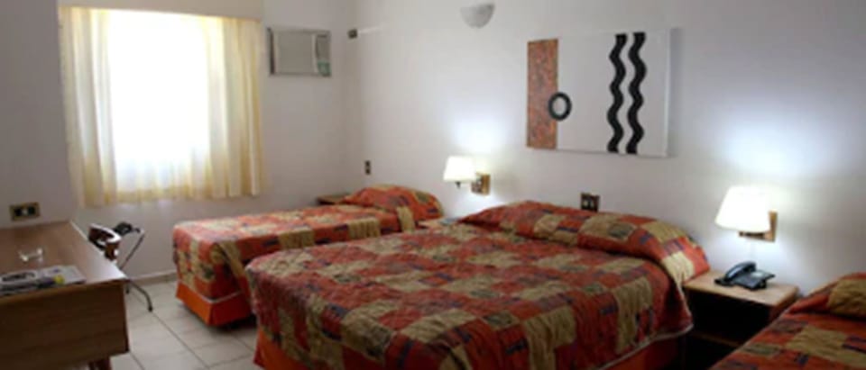 Family Room | Minibar, in-room safe, desk, bed sheets