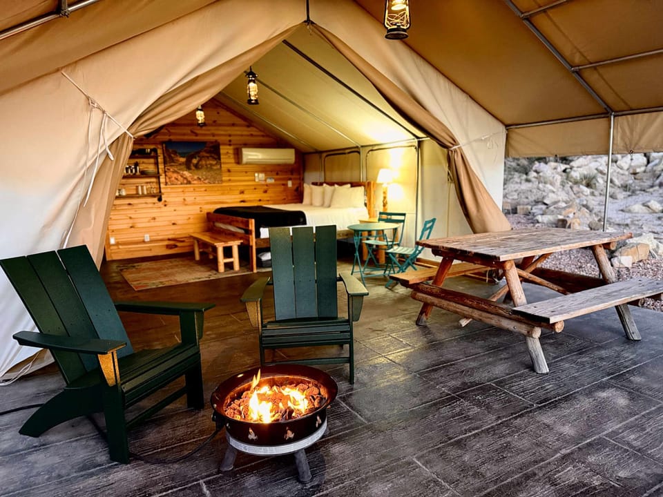 Covered patio at your glamping tent with outdoor seating, a fire pit, picnic table, and room to relax after a day exploring Zion National Park and Bryce Canyon.