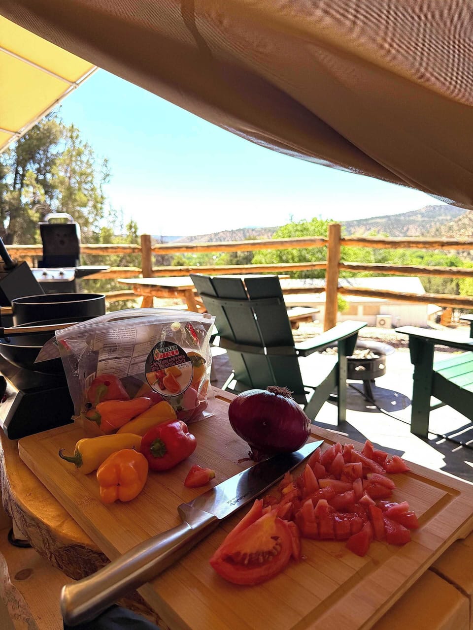 Outdoor cooking and dining setup with a BBQ grill, prep space, hot plate, kitchenware, and utensils for relaxed meals at your glamping tent.