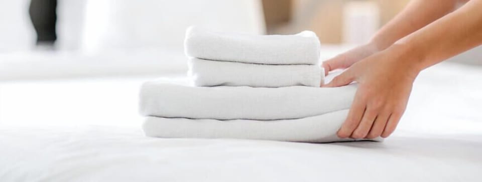 Fresh towels placed on your bed, ready for your arrival. The inviting bedroom welcomes you with crisp linens and thoughtful touches for a relaxing stay.
