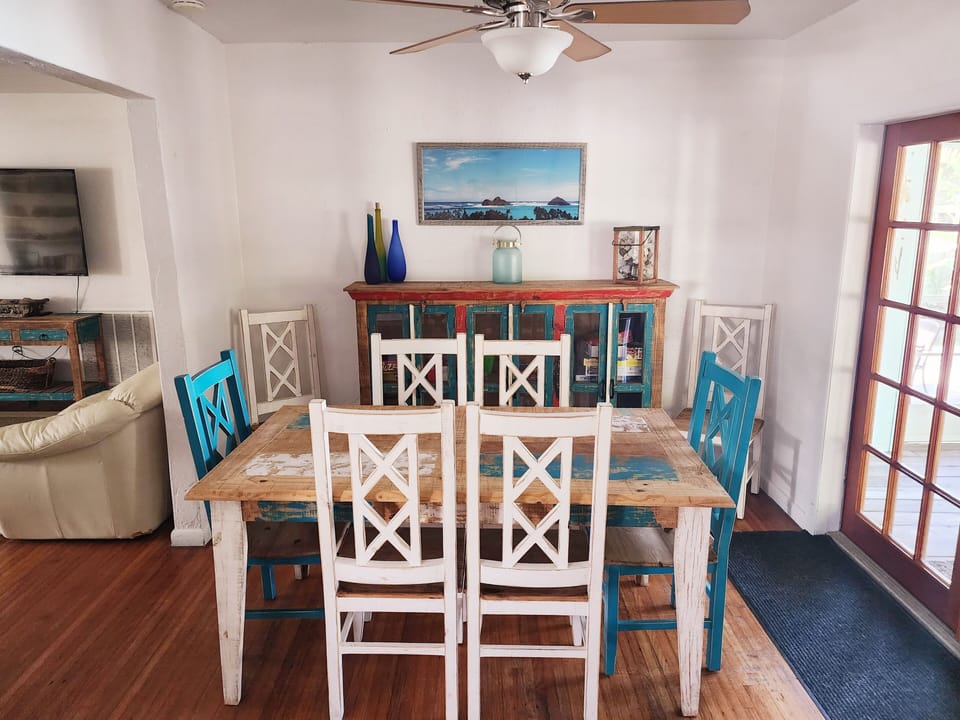 Dining room with 8 chairs, looks out to porch.