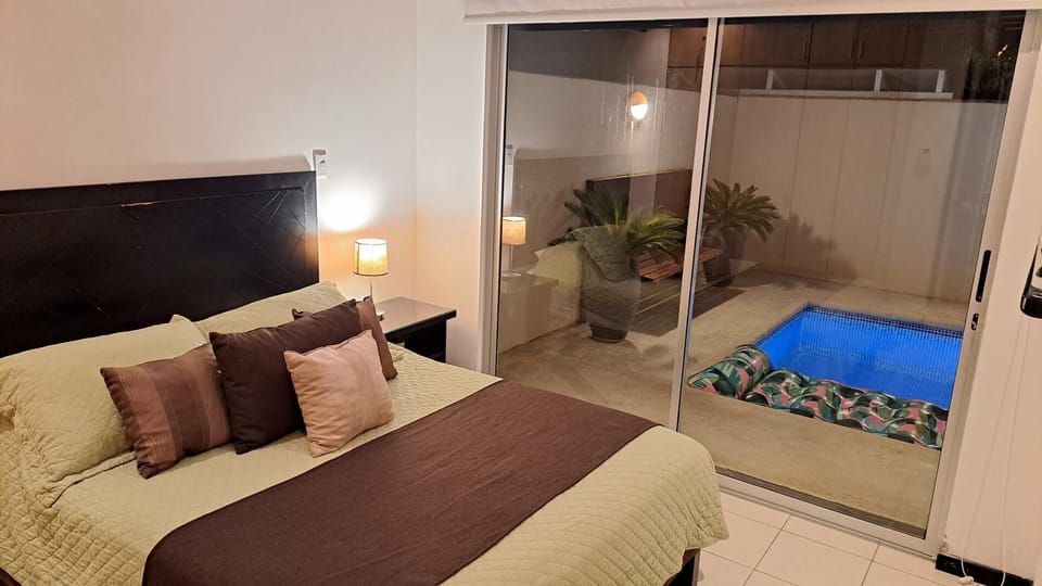 Master bedroom with Queen bed, TV and sliding door to pool terrace
