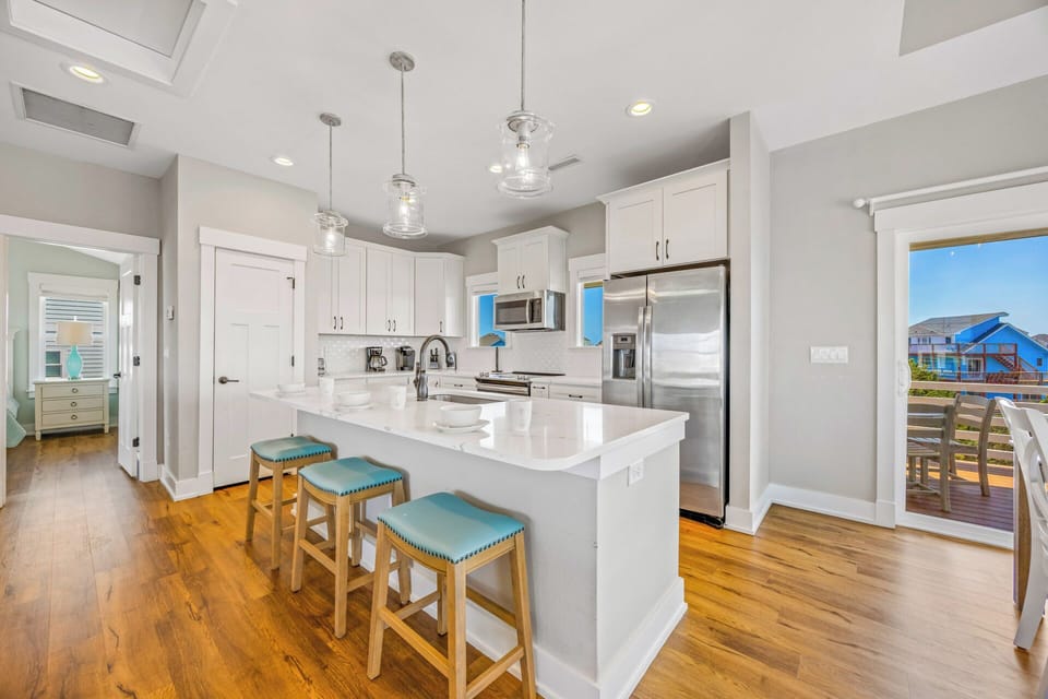 Picture yourself preparing meals in this bright, modern kitchen with gleaming white counters, stainless appliances, and a welcoming island where your group can gather over morning coffee.