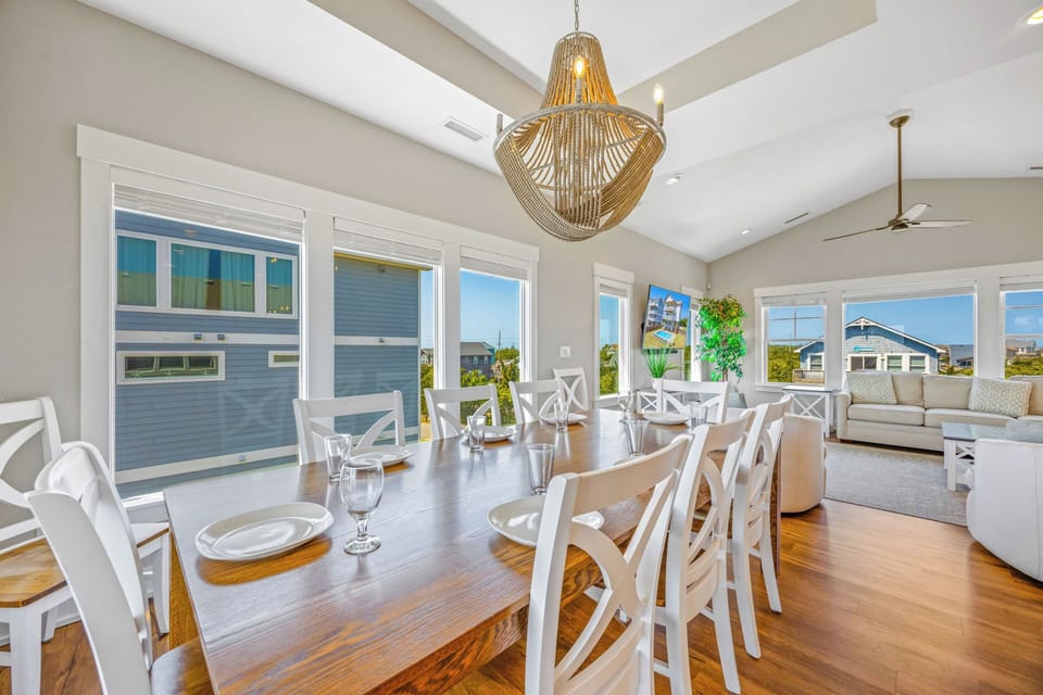 Picture yourself gathering at this elegant dining table for memorable meals, surrounded by coastal charm and natural light streaming through oversized windows.
