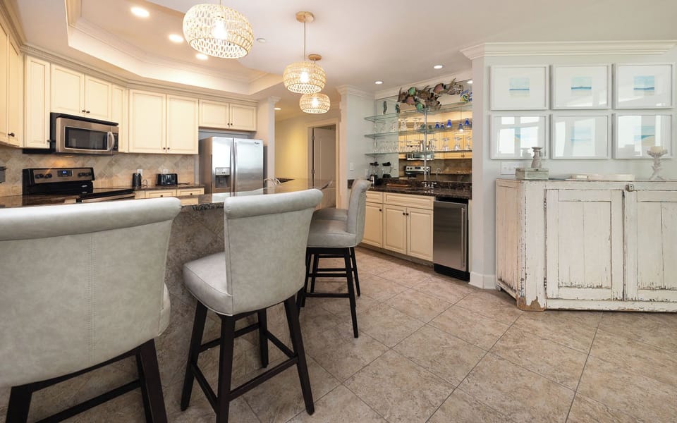 The kitchen features granite countertops, stainless appliances, and a stylish wet bar, perfect for entertaining