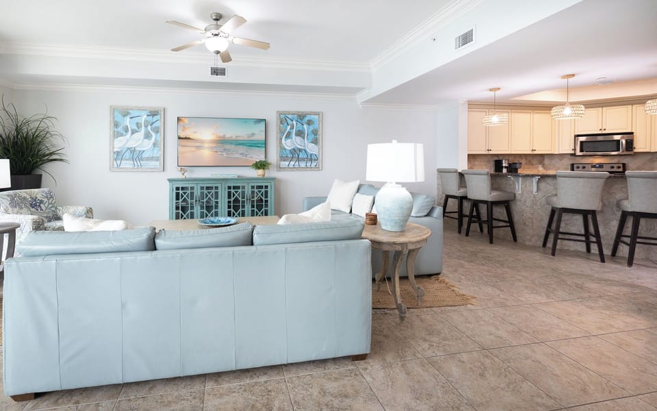The living space features a large TV, comfortable seating, and a stylish blue accent table, perfect for relaxation