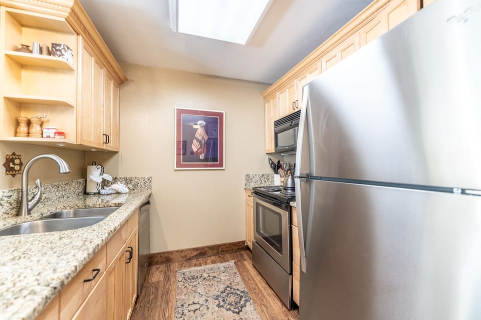 Your fully-equipped kitchen features granite counters, stainless appliances, and a skylight that fills the space with natural light for cooking.