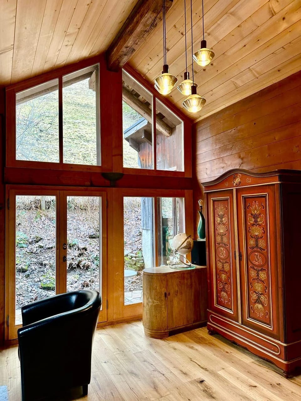 A beautiful window with a high selling point offers a view of the hillside and forest.