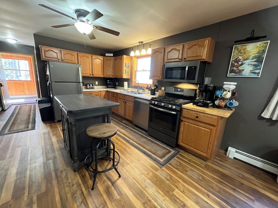 Kitchen with a full-sized refrigerator, stove, microwave, oven, and center island.