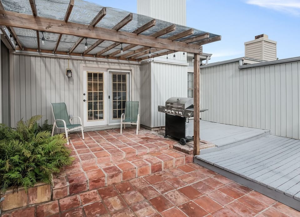 French doors from living room lead to back patio with festive lights for evening