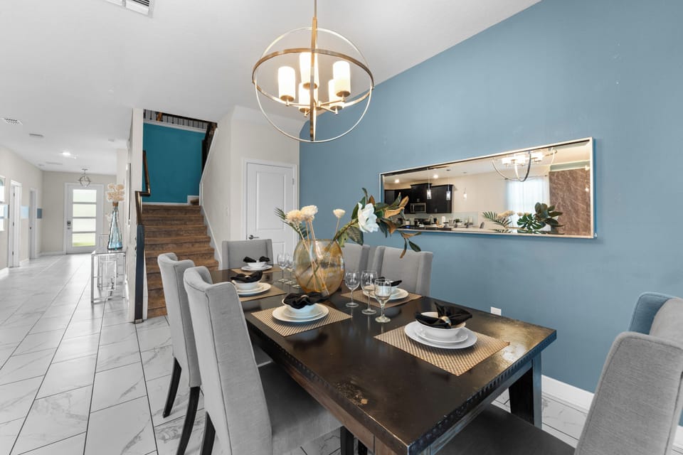 Gather around your stylish dining table, beautifully set and ready for memorable meals together. The open layout connects you to the modern kitchen, making hosting effortless and enjoyable.