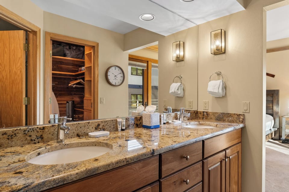 Pamper yourself at this elegant granite vanity with dual sinks, perfect for your morning routine in this luxuriously appointed bathroom.