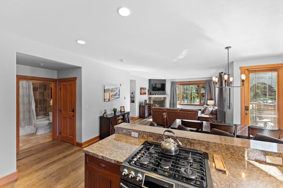 Your open-concept space flows seamlessly from granite kitchen to cozy living area, with warm wood accents creating an inviting atmosphere.