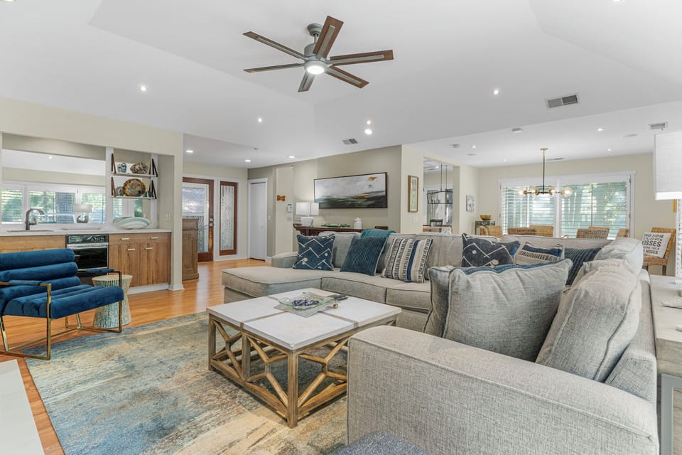 Great room with sitting and dining area, access to back deck and views of lagoon