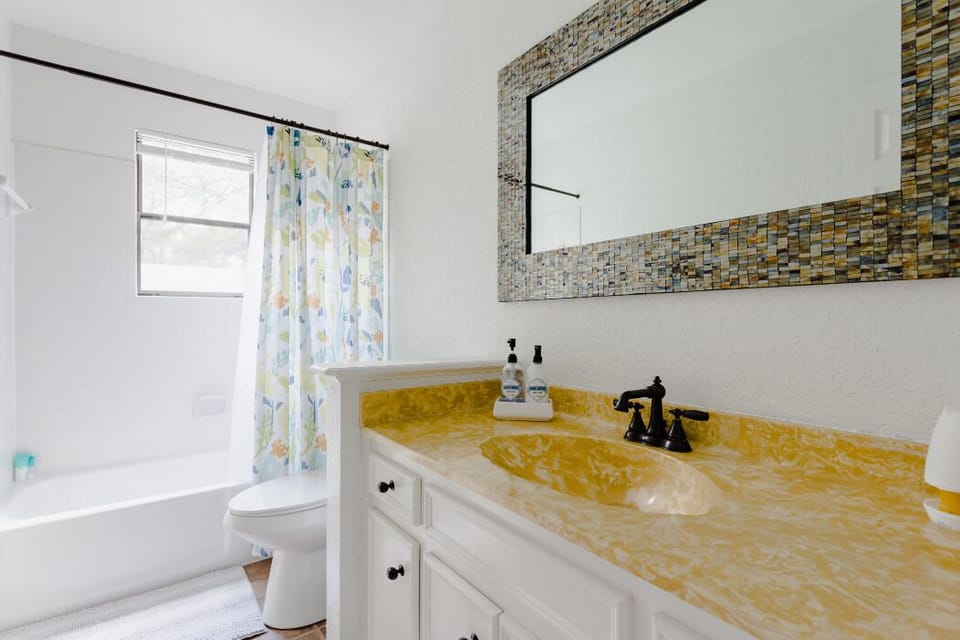 Gleaming granite counter top, large unique mirror, fluffy bath mat