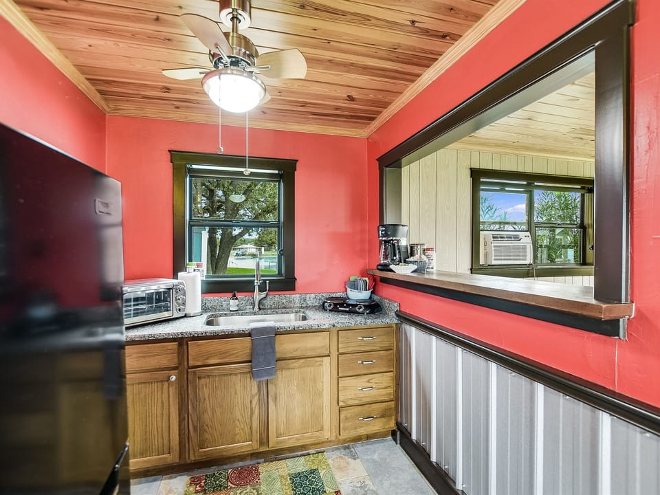 The guesthouse kitchenette includes a small refrigerator, toaster oven, coffee maker, and a two-burner stovetop unit.