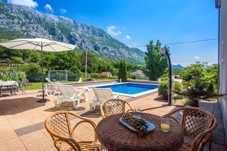Pool with mountain view and fenced playground for children