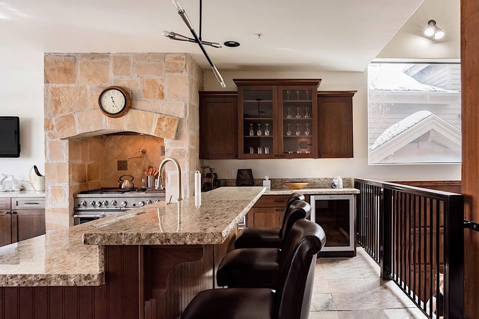 Warm, inviting cooking space with granite counters and bar seating.