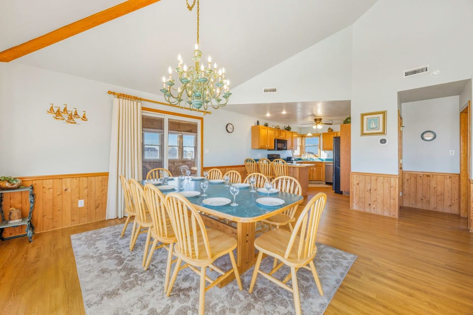 Gather your group around this spacious dining table under an elegant chandelier, with the fully-equipped kitchen just steps away for easy meal preparation.