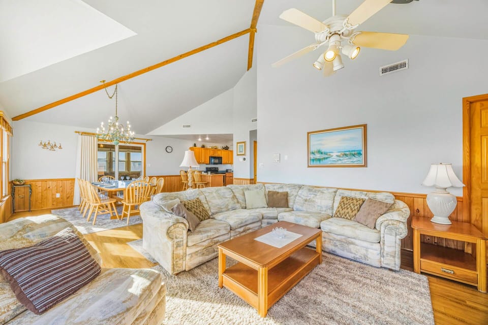 Unwind in your spacious living room featuring a plush sectional sofa, vaulted ceilings with rustic beams, and an open layout perfect for gathering.