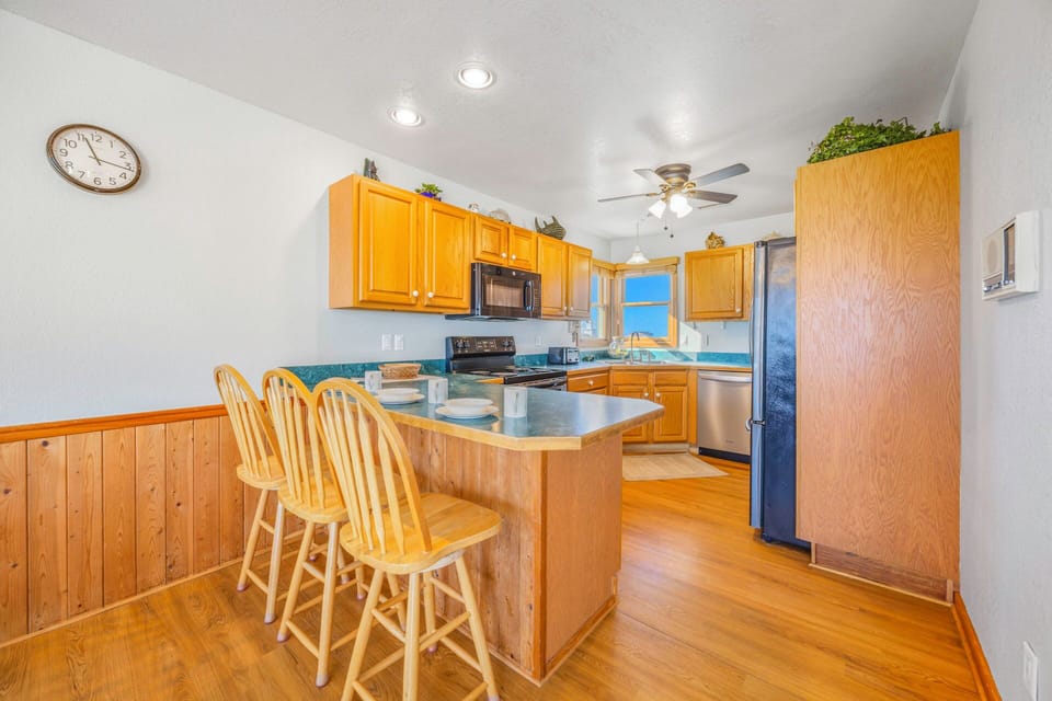 Your fully equipped kitchen features warm wood cabinets, modern appliances, and a breakfast bar perfect for morning coffee.