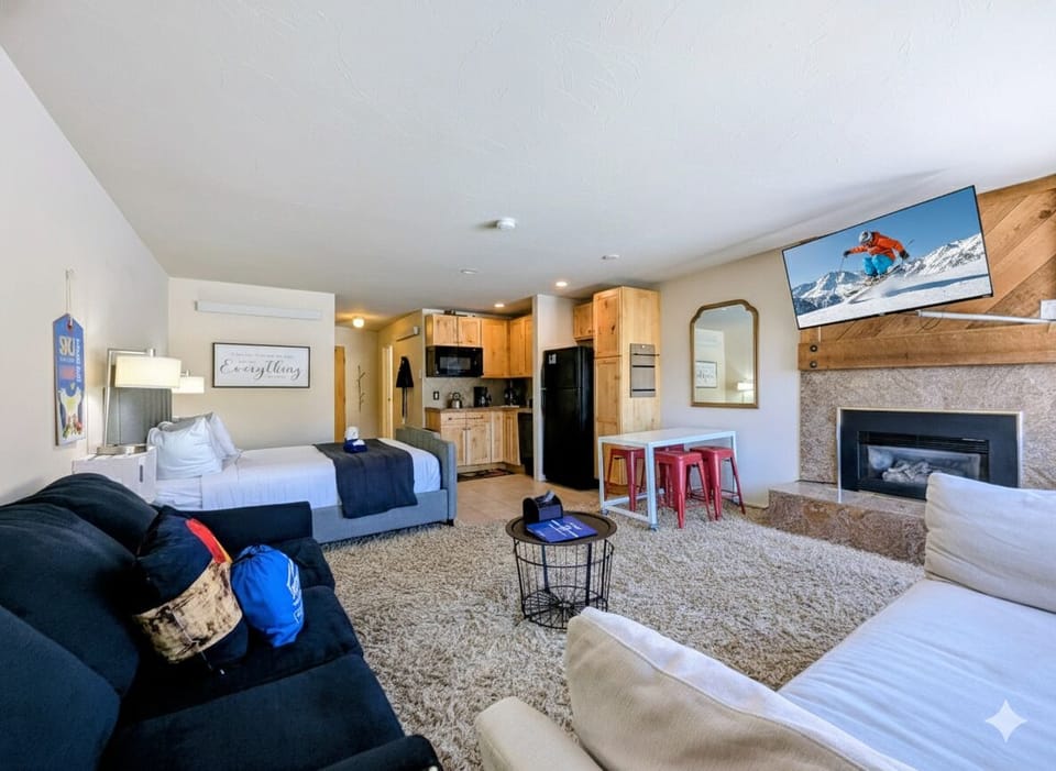 Unwind in your stylish open-concept suite with cozy fireplace, full kitchen, and comfortable seating perfect for mountain getaways.