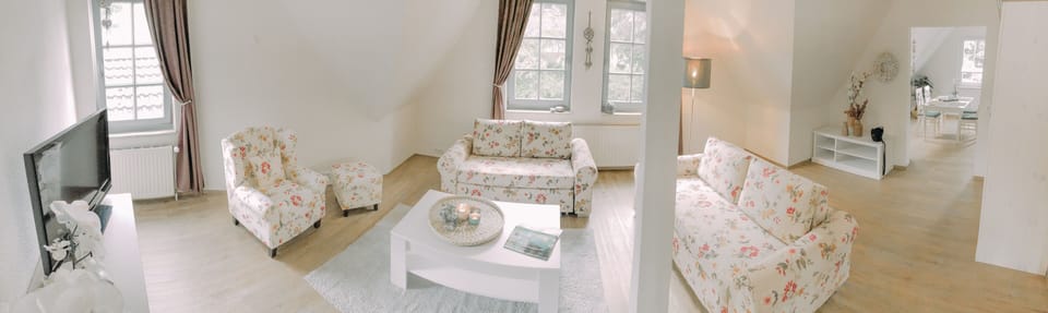 Deluxe Apartment | Living area | Flat-screen TV, books