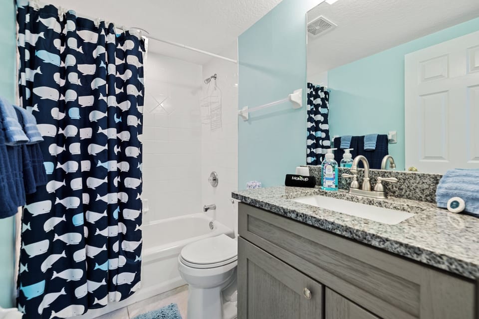 A modern and updated guest bathroom with a shower tub combo.