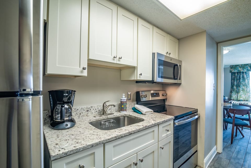 The kitchen has a full size refrigerator, oven, four burner stove and microwave 