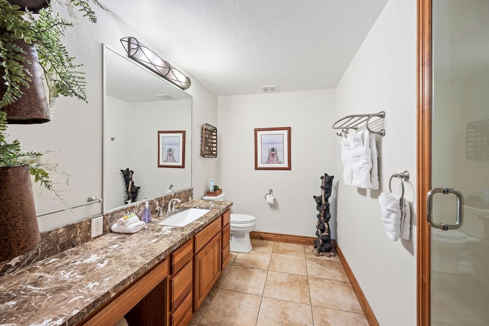 Unwind in your spacious marble-topped bathroom featuring luxurious granite countertops, plush towels, and thoughtful amenities for your comfort.