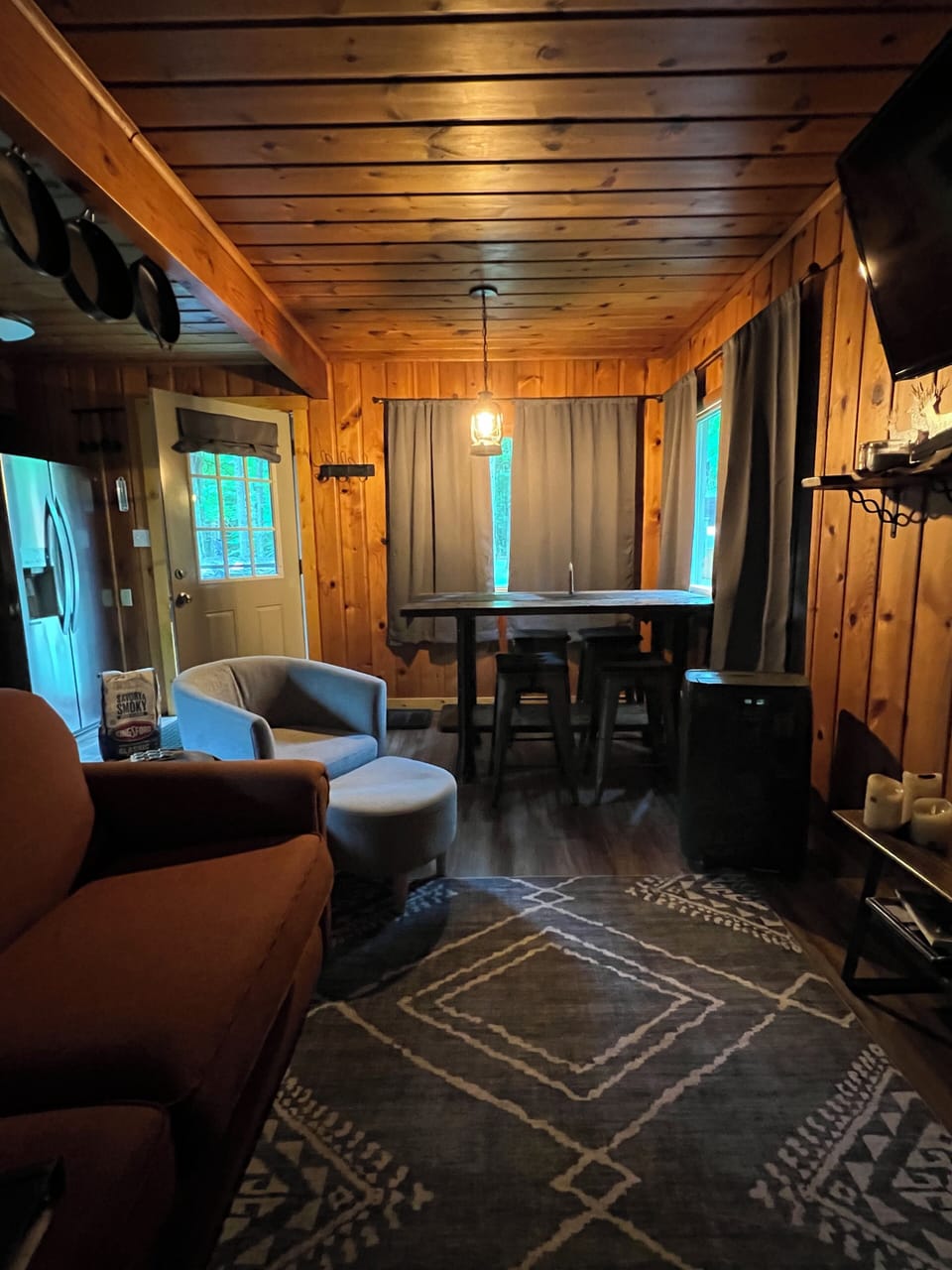 Living room with couch and chair, table 4 stools. 