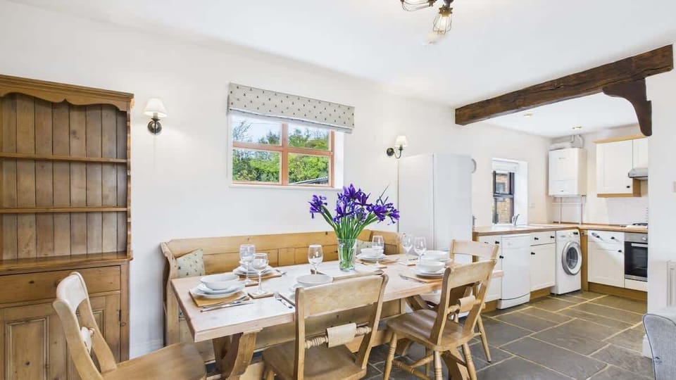 A fully equipped farmhouse-style kitchen with modern appliances, including an oven, hob, and dishwasher.