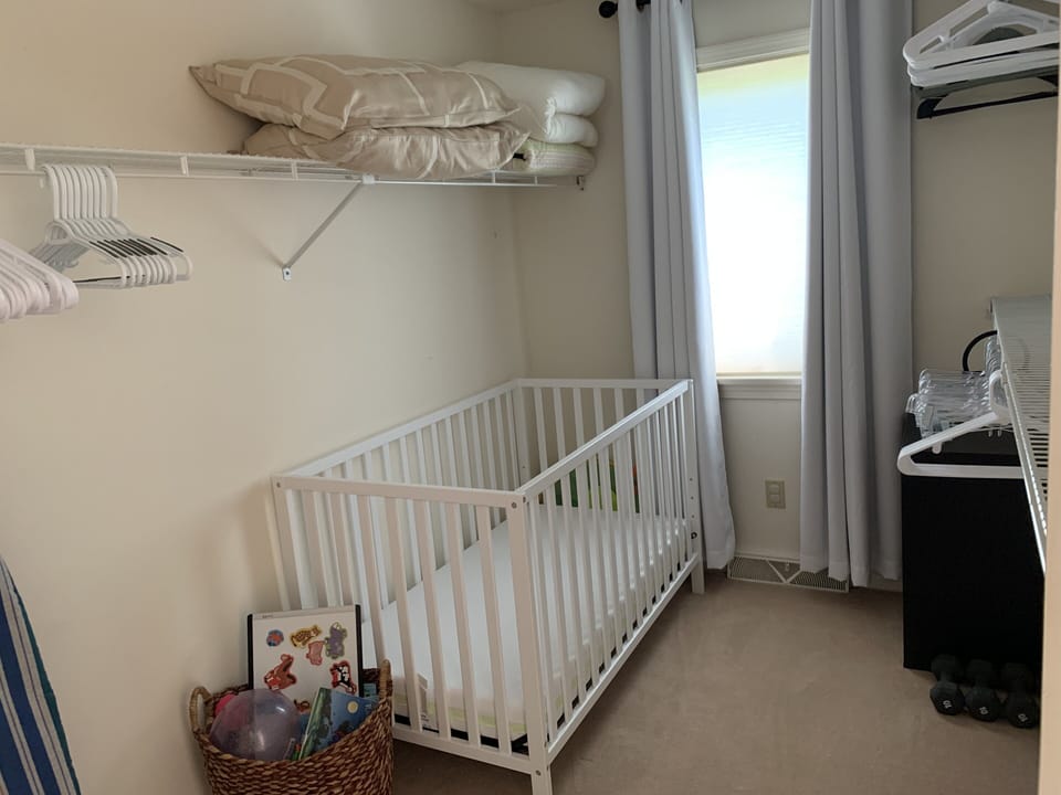 Bedroom #1 (1st Fl Master) walk-in closet with blackout curtains & crib for baby